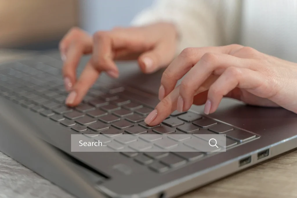 Imagem de uma pessoa digitando em um laptop, representando a busca por soluções sobre indexação de páginas e o que fazer quando o Google não indexa seu conteúdo.