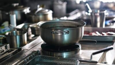 Utensílios e panelas de aço inoxidável em ambiente profissional