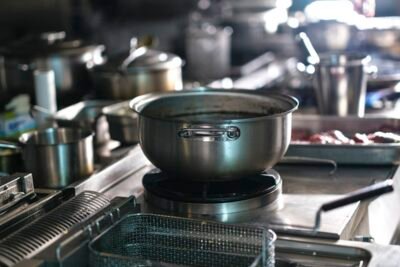 Utensílios e panelas de aço inoxidável em ambiente profissional